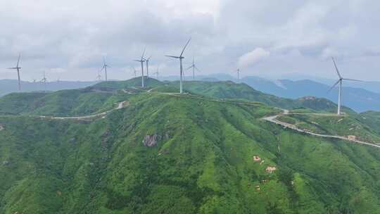 绿色山坡上矗立着的风力发电机群