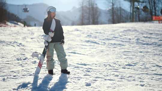 冬季运动和娱乐妇女在滑雪板设备站在斜坡上