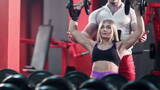 女人和她的私人教练在健身房用杠铃锻炼高清在线视频素材下载