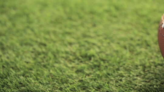 美式足球特写在绿草上。