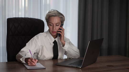 忙碌的中年商务女性在办公室多任务处理使用