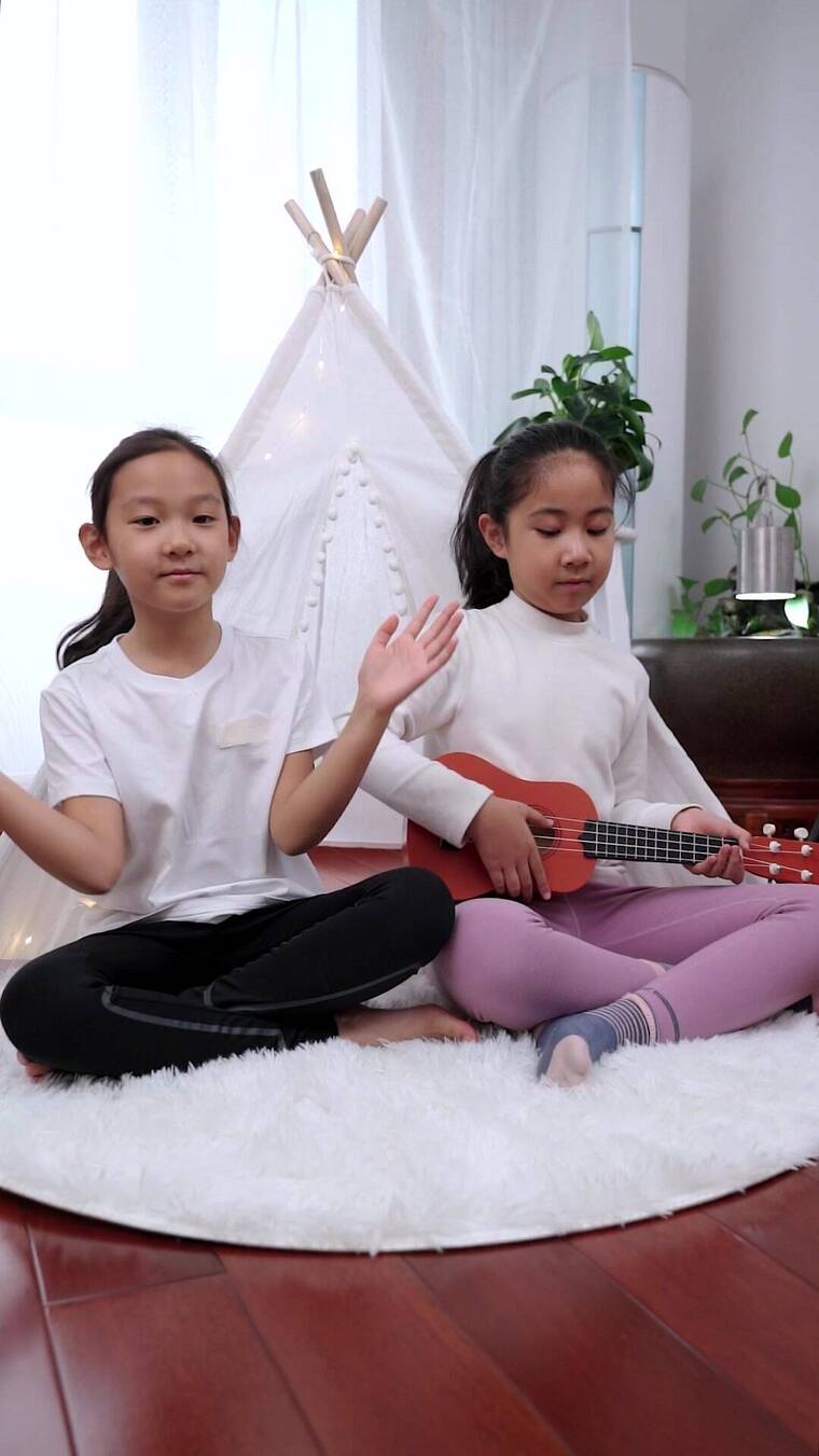 坐在地上弹奏尤克里里的女孩