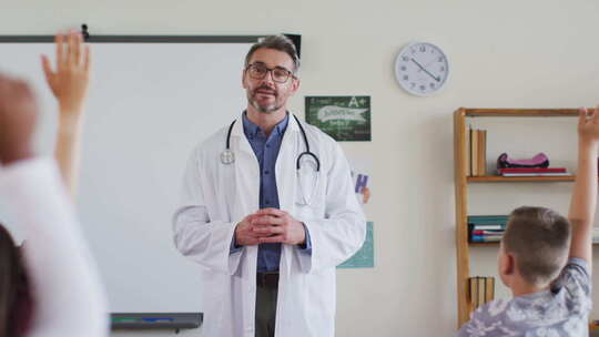 高加索男性医务工作者戴着透视镜，站在教室里提问