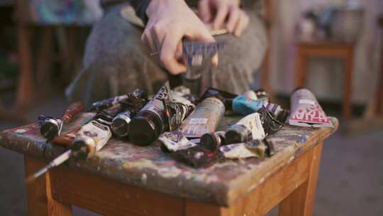 将油漆放在调色板上的人