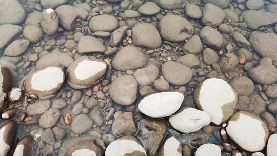 鹅卵石清澈水面随微风缓缓流淌背景