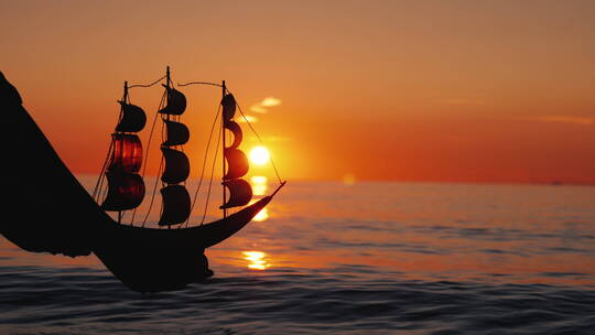 日落时分海上的玩具帆船