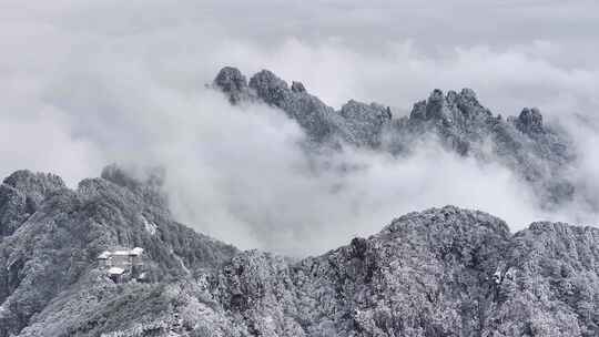 云雾缭绕的雪山及山间小屋景观