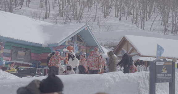 雪地上的彩色小屋及穿着厚外套的人群