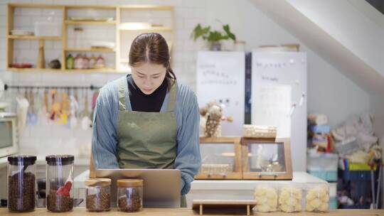 年轻女性烘培店长在吧台服务顾客