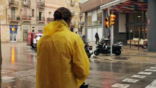 雨中欧洲城市路灯上带伞和雨衣的商人游客