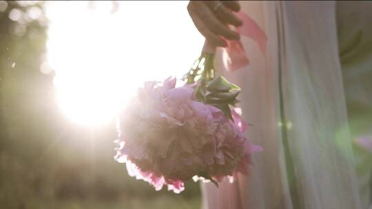 阳光下拿着手捧花的新娘