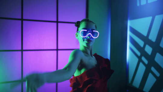 现代年轻女性戴着荧光眼镜在彩色霓虹灯背景下跳舞性感淑女概念
