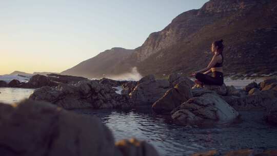 海浪拍打着海岸时，一个女人坐在莲花姿势的