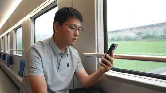 男子在卧铺火车过道上使用手机
