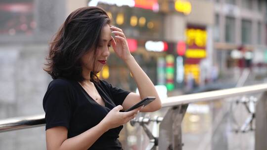 年轻美女在城市街头看手机浏览社交媒体视频素材模板下载
