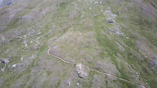 为步行者和登山者提供的长满草的山脉立面的无人机鸟瞰图