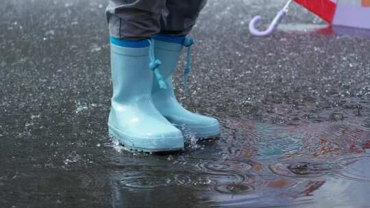 一个穿着防水靴的人踩在地上的雨水残渣