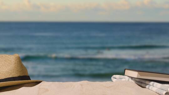 夏季假期概念沙滩上的太阳帽书籍