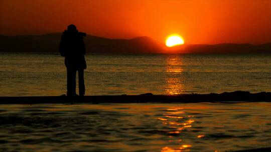 落日在湖水中央拍照的浪漫情侣