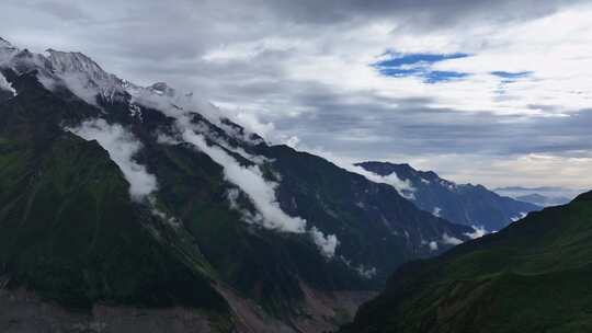 航拍云雾缭绕的四川甘孜海螺沟景区雪山风光