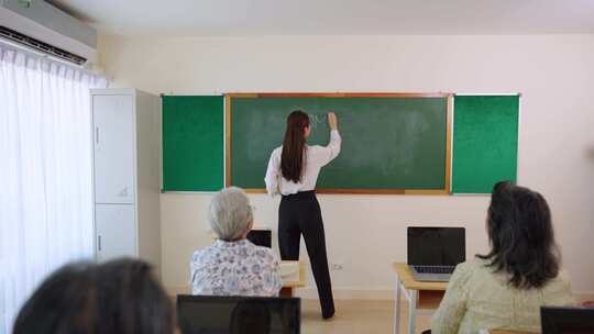 亚洲女教师在学校课堂上教成熟的学生。