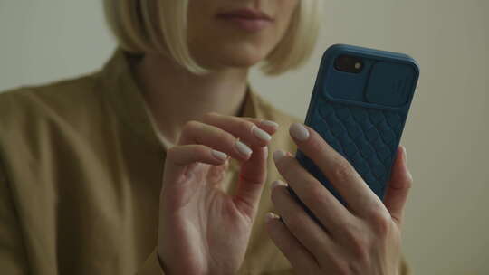 女人在深蓝色外壳中使用智能手机
