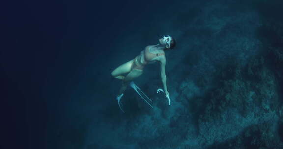 女子自由潜水员在蓝海深海自由潜水冥想和享