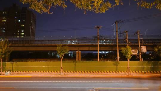 夜晚马路车流桥梁上行驶的地铁