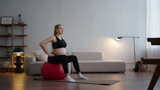 平衡运动与健身房球孕妇独自训练在家庭运动