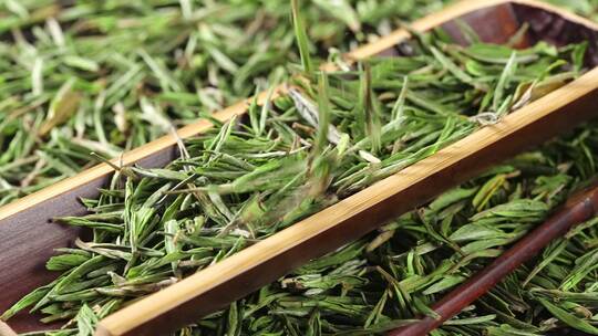 散落到桌上竹槽里的绿茶龙井茶叶