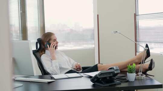 女职员坐在办公室打手机