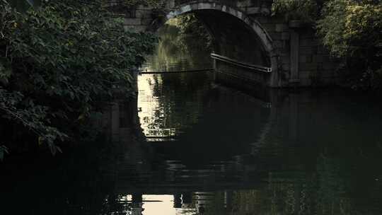 古桥在阳光下透过的倒影在水面