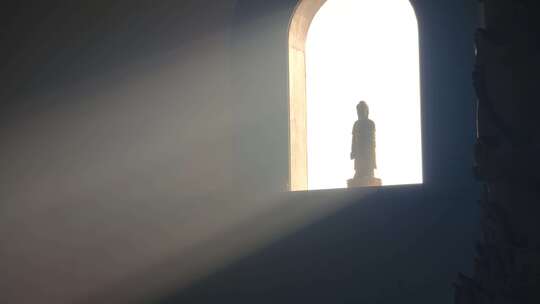 寺庙窗户透过丁达尔光照射在佛像上