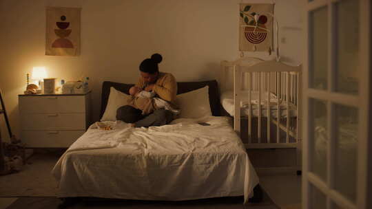 关爱年轻的西班牙裔妇女在卧室母乳喂养婴儿