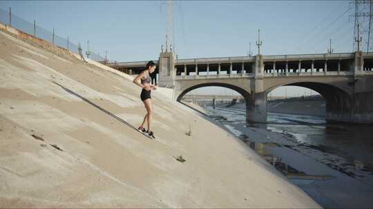 女人从排水系统的陡峭墙壁上跑下来