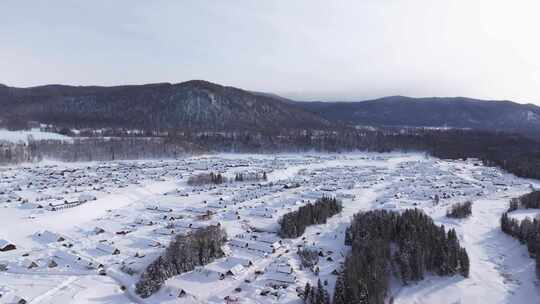 航拍新疆禾木雪景森林雪地小木屋禾木桥雪山