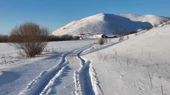 冬日雪山下的雪地车辙山里人家