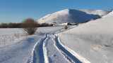 冬日雪山下的雪地车辙山里人家高清在线视频素材下载