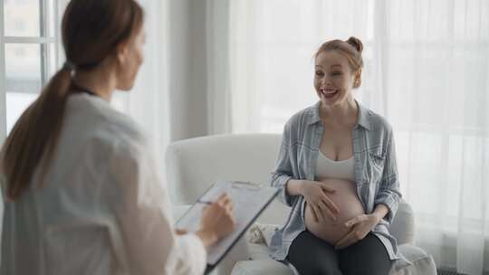 孕妇咨询医生微笑孕妇病人回答妇科医生
