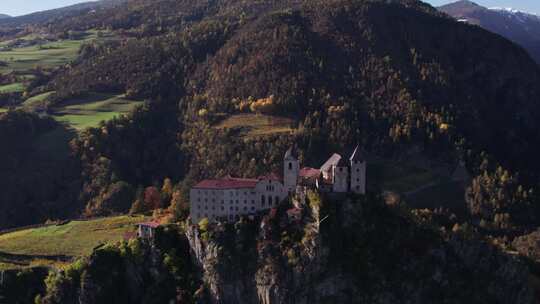 意大利阿尔卑斯山岩石山顶上的萨本修道院建筑，空中