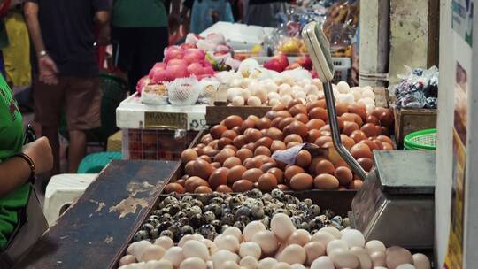 女性在市场摊位上买鸡蛋