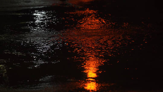 路面溅起水花雨滴红绿灯倒影