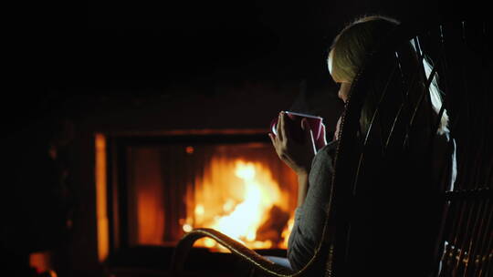 女人在壁炉旁喝茶