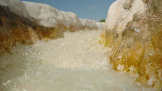 白色石头排水沟，水从泉水中流过，有方解石