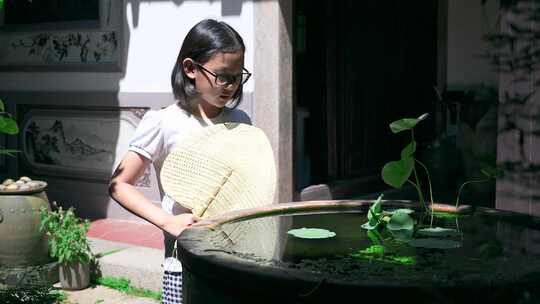 4K升格实拍在中式庭院鱼缸边乘凉的女孩