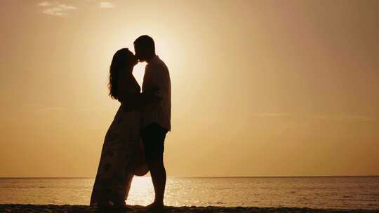 情侣在海边牵手拥抱亲吻