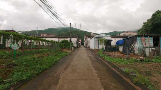 一架无人机在一座山的背景下飞过一个中国村