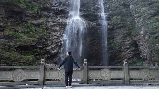 女性人物背影感受亲近自然登顶山峰瀑布水流