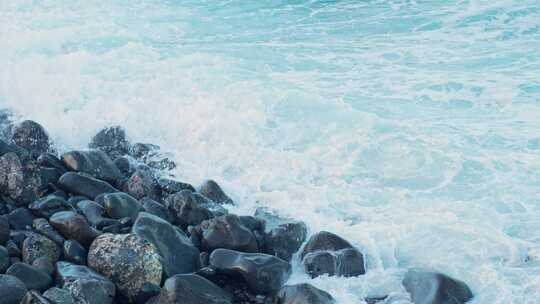 水波冲向海边的鹅卵石，静态特写慢动作视频素材模板下载