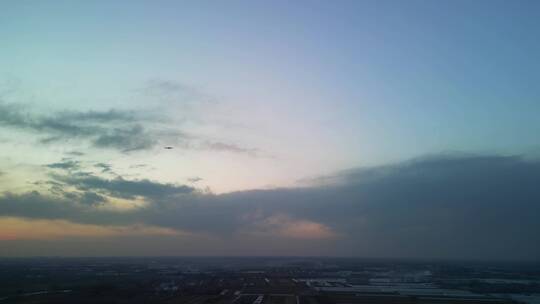 4K航拍-夕阳中飞机下降高度掠过天空